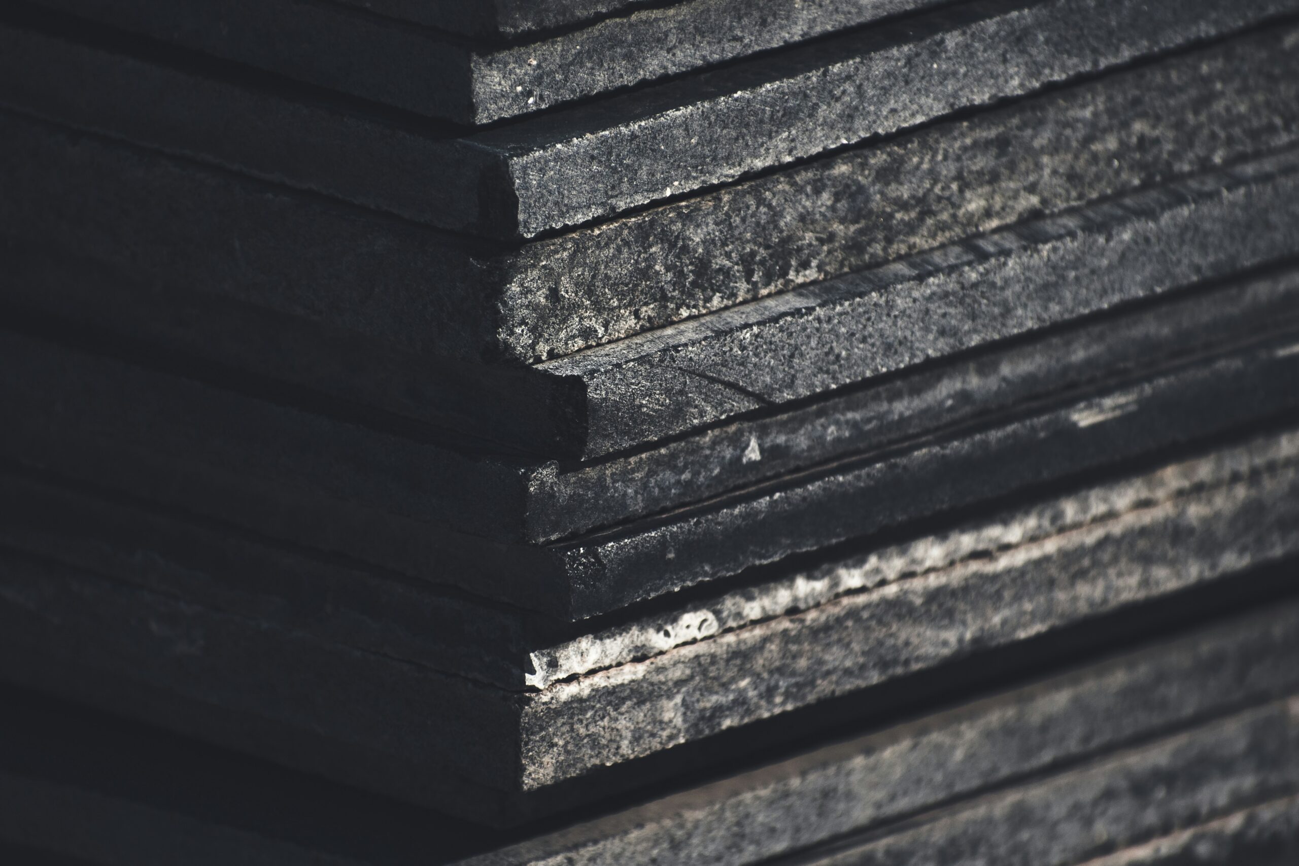 An image of a stack of black and brown stone slabs